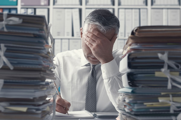 Stressed manager working at office desk in Wrexham